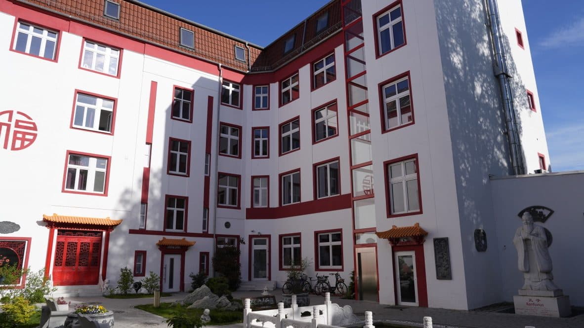 Weiter Blick über den Innenhof mit Balustrade, Statue und umlaufender Fassade